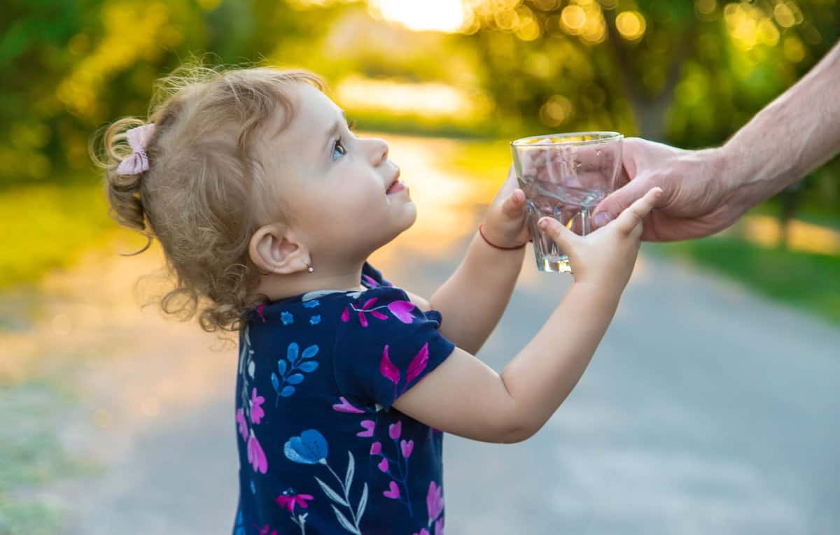 Bimba che beve acqua del rubinetto